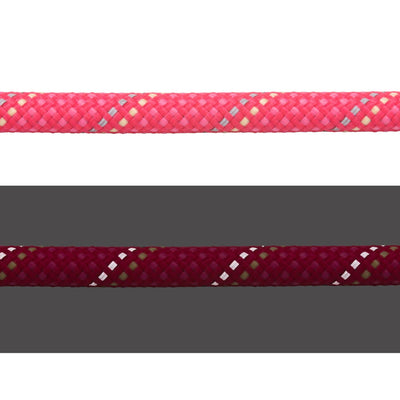 Close-up of the Ruffwear Knot-a-Long rope in Fireweed Pink showing the kernmantle weave in daylight (top) and reflective threads illuminated in low light (bottom)