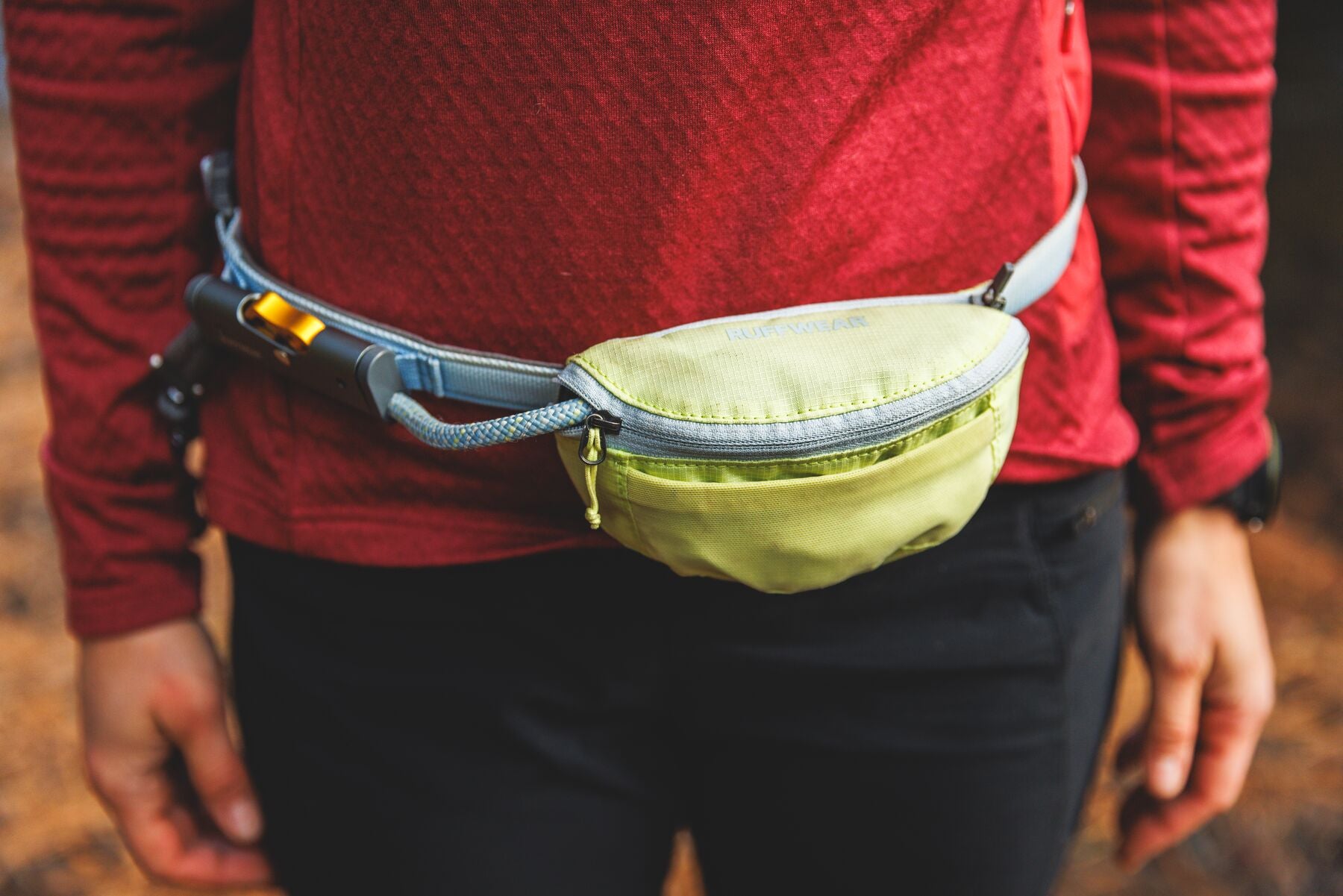 Person wearing the Ruffwear Hitch Hiker Dog Lead in Sunny Lime as a hands-free waist belt showing the stow bag and HitchLock rope adjuster
