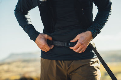 Ruffwear Ridgeline Lead being worn hands-free around the waist on a trail walk with open landscape behind