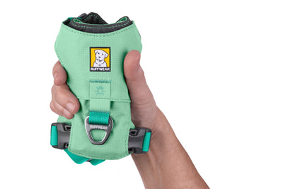 Ruffwear Hi & Light dog harness in Sage Green held in one hand to show its compact, lightweight construction, on white background